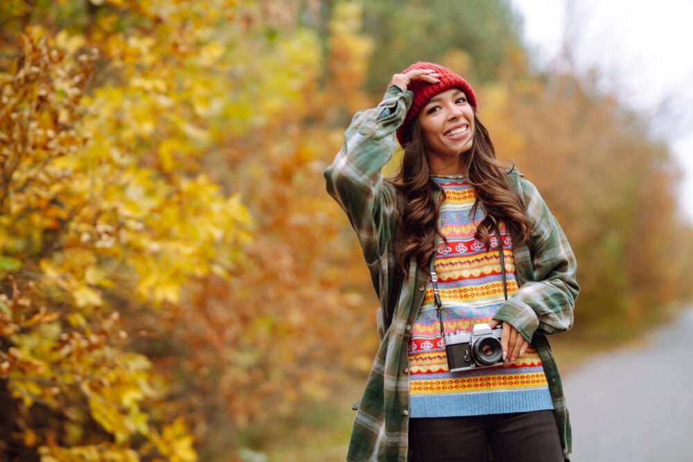 Vacker ung kvinna fotograferas med retro kamera. Vila, avkoppling, resor, livsstil.